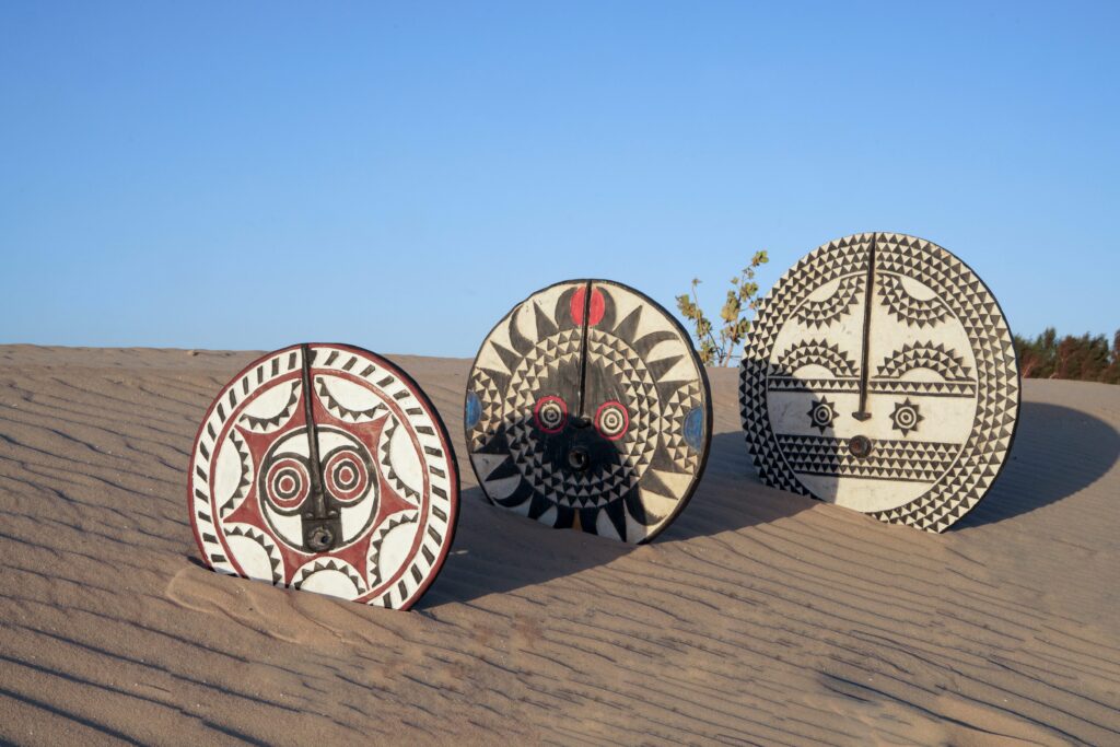 3 Boucliers masques BWA de tailles et forme différentes installés dans le sable