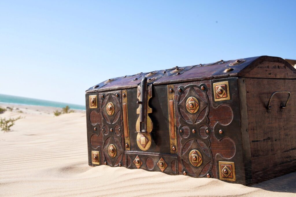 image d'un coffre maure en bois posé dans le sable